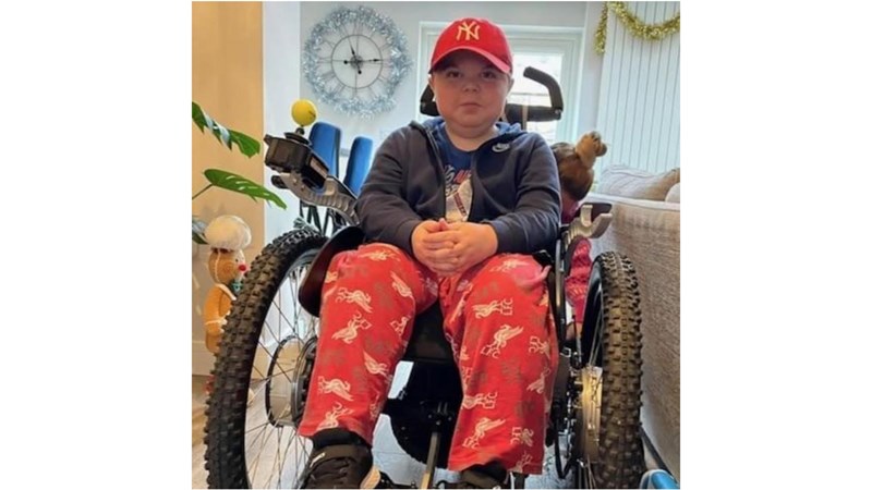 Tom, 15, sat in his powerchair at home